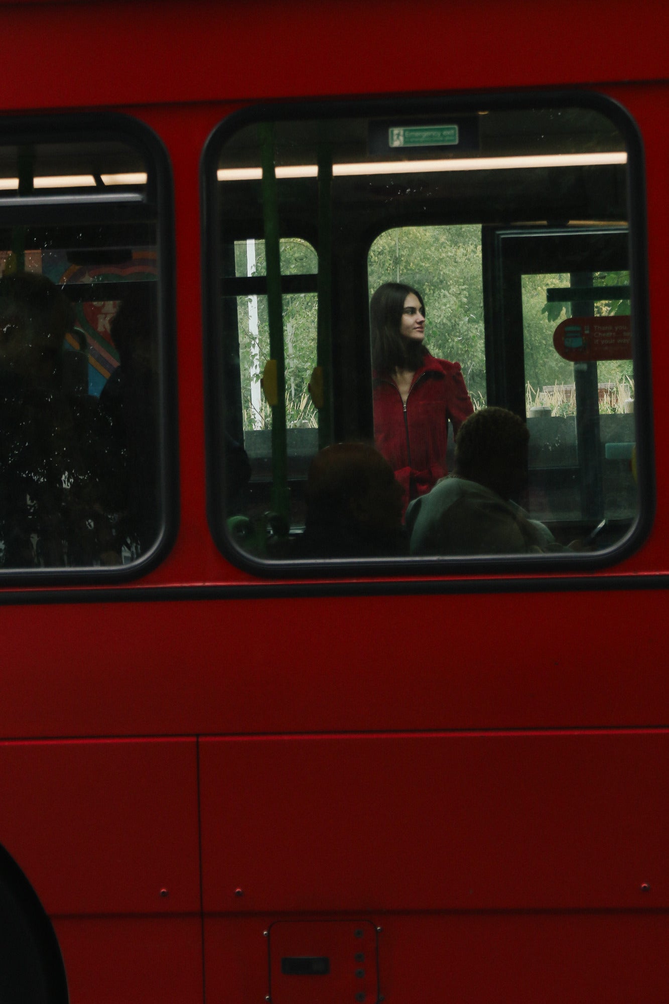 woman wearing the res winston jumpsuit standing near a red bus