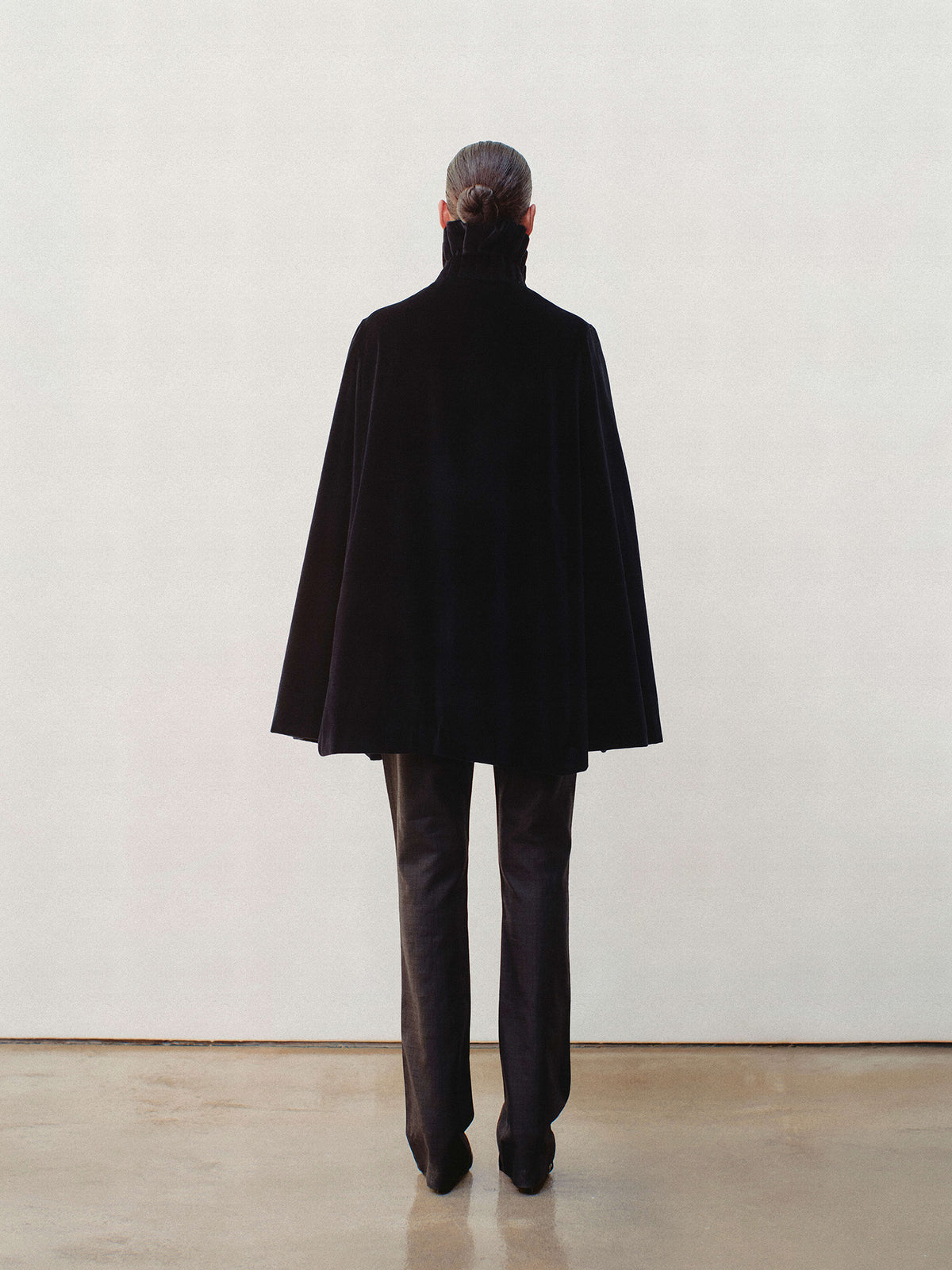 back view of model wearing the Portobello Cape in black, as seen in The Gentlemen