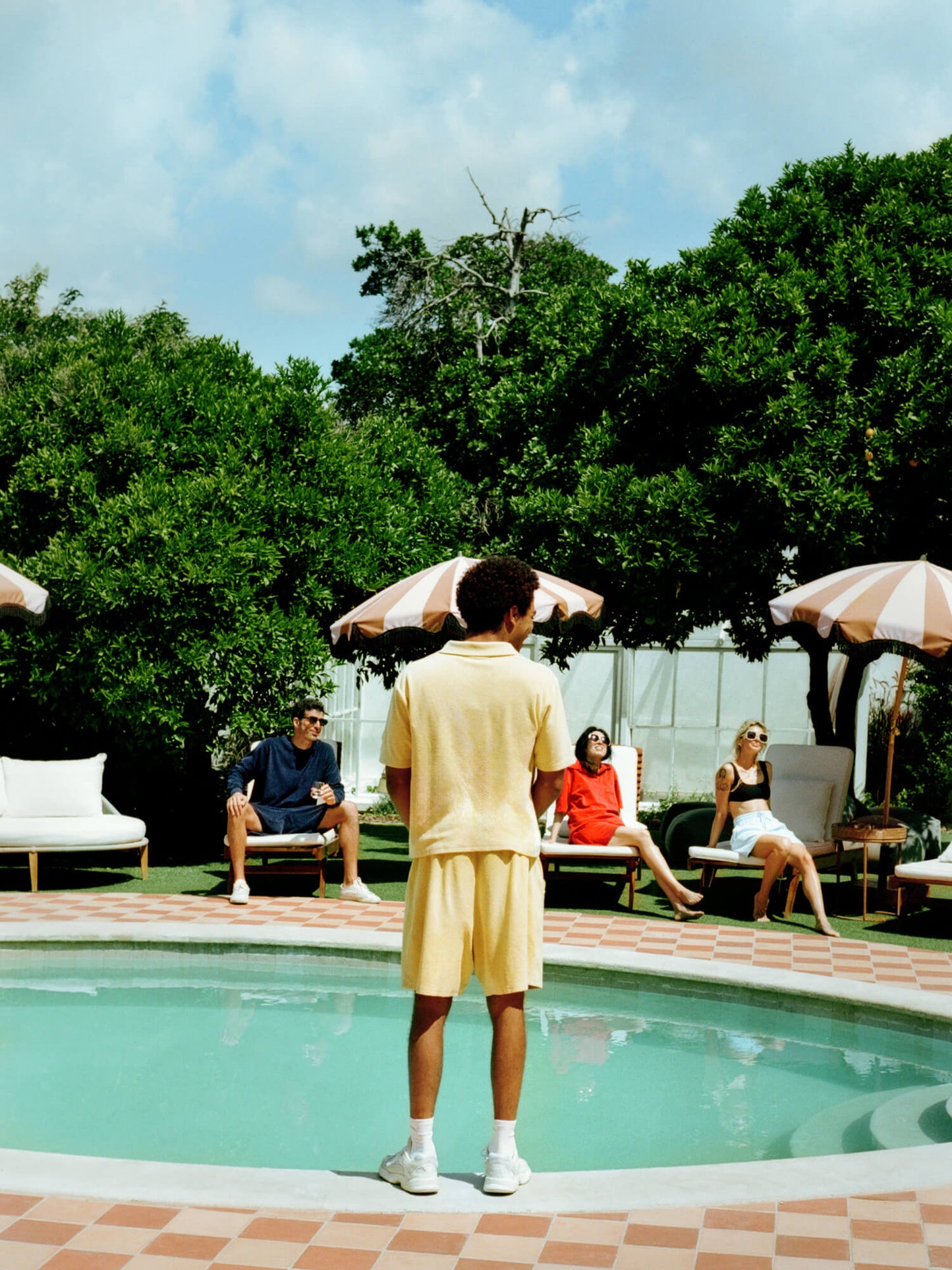man sat by pool with friends wearing Organic Terry Polo in Deep Ocean Blue