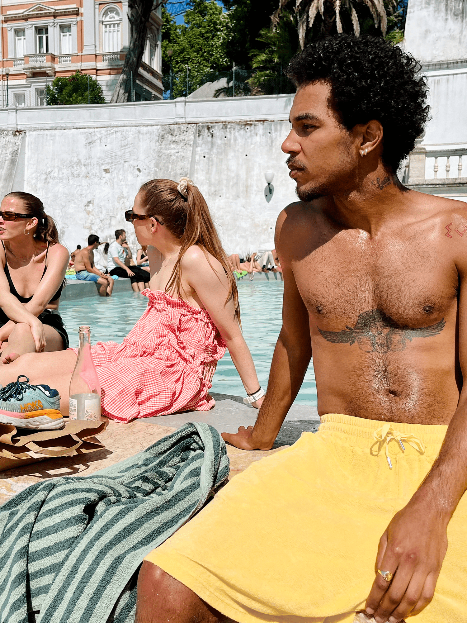 man sat by water wearing Organic Terry Shorts in golden sand