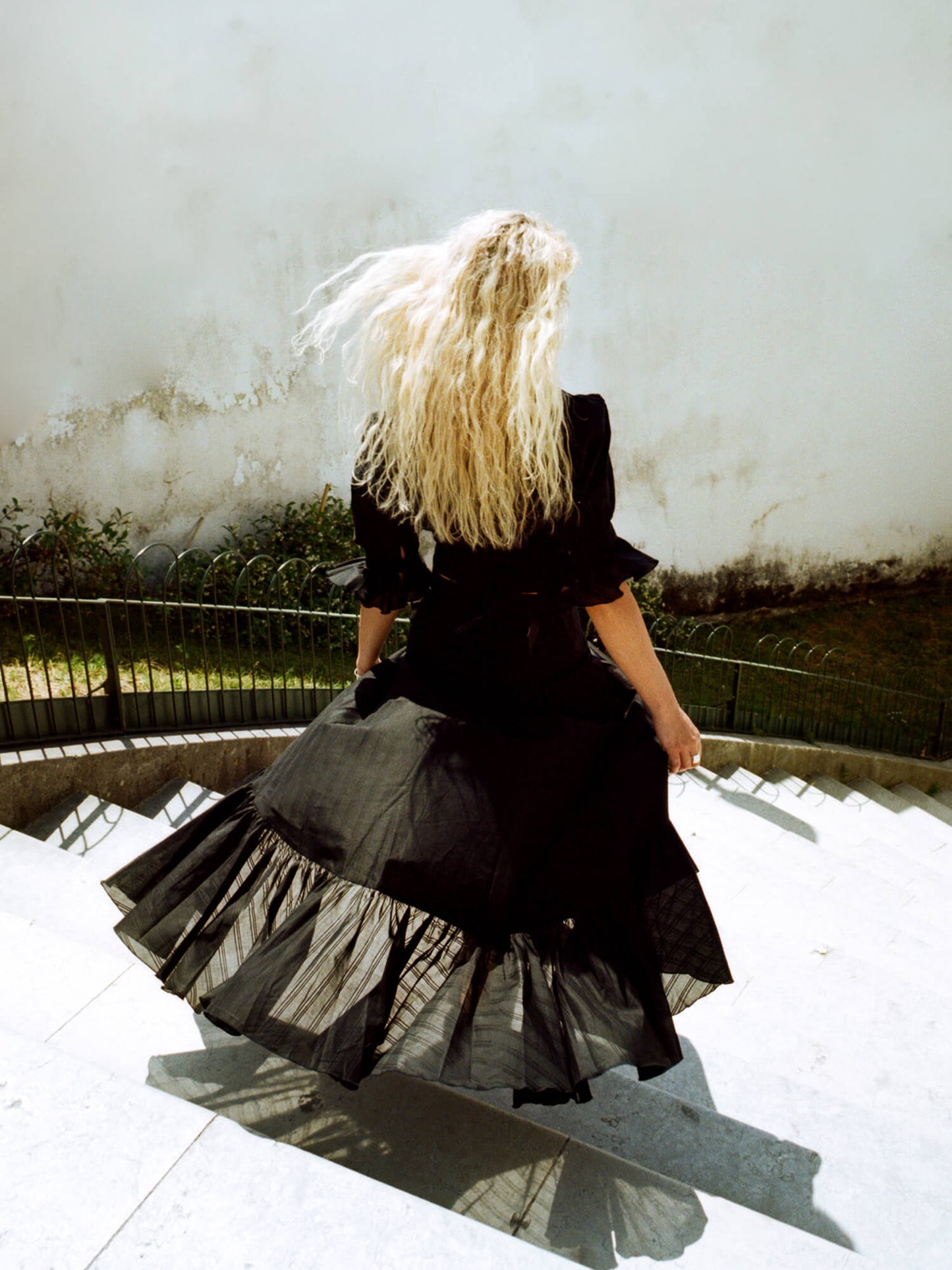 woman walking downstairs wearing The Wrap Skirt in black