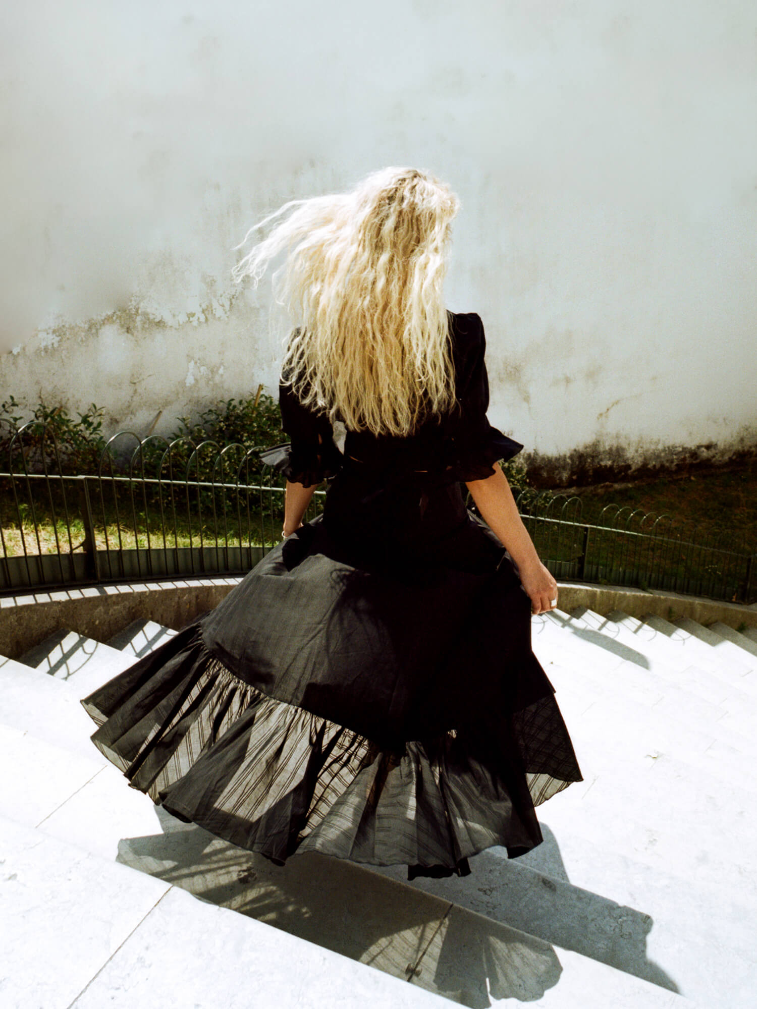 woman walking downstairs wearing The Wrap Skirt in black