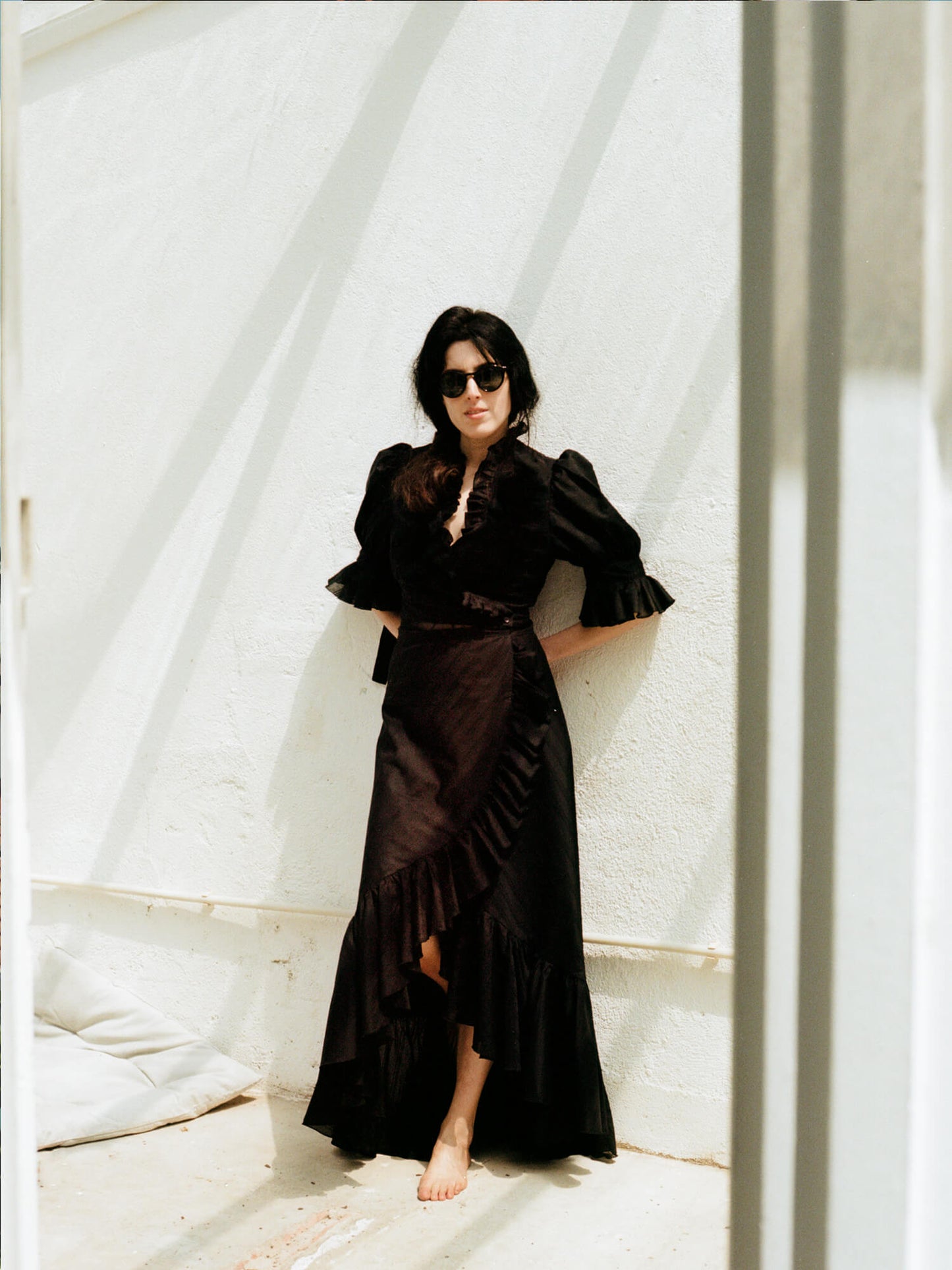 woman wearing The Wrap Skirt in black barefoot in sunglasses