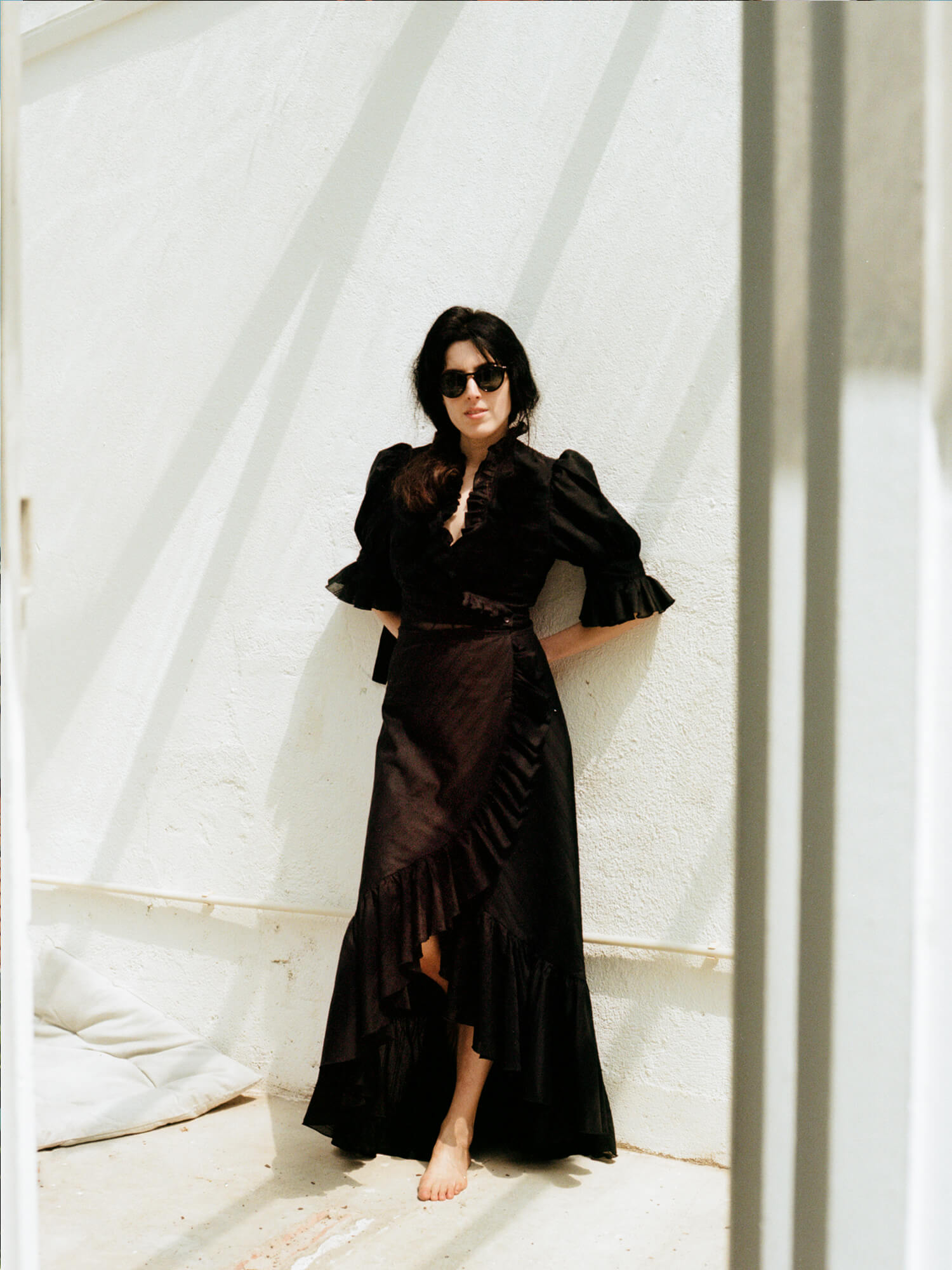 woman wearing The Wrap Skirt in black barefoot in sunglasses