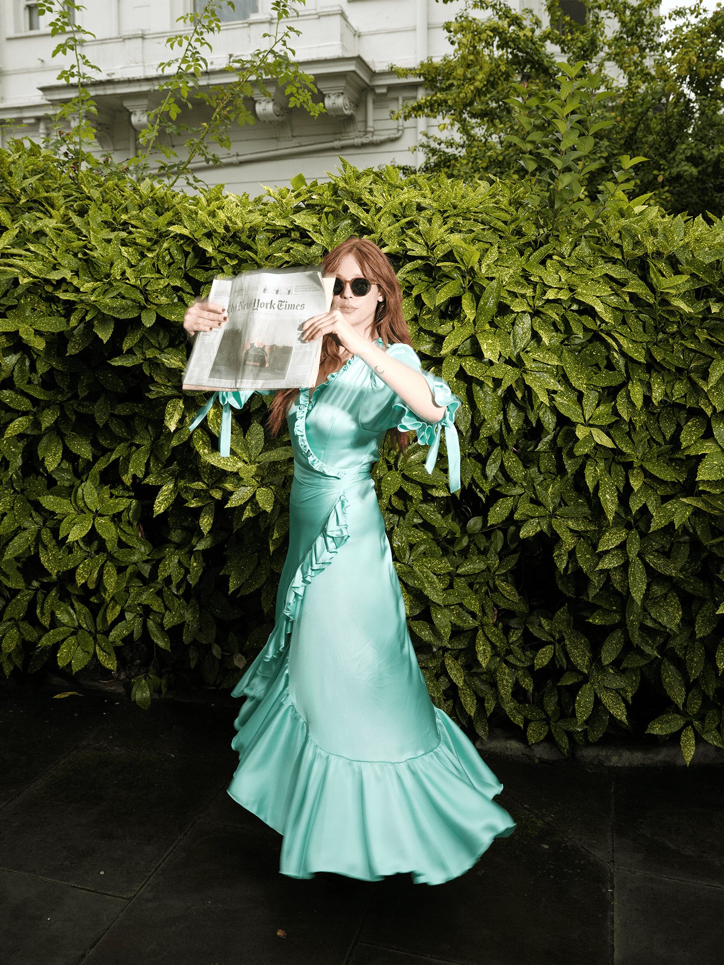 woman wearing The Wrap Dress 2.0 in mint green outside with newspaper