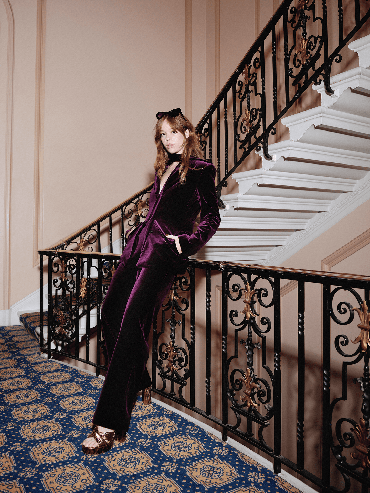women modelling Cotton Velvet All-Day Suit Trousers in purple whilst leaning on  grand bannister 
