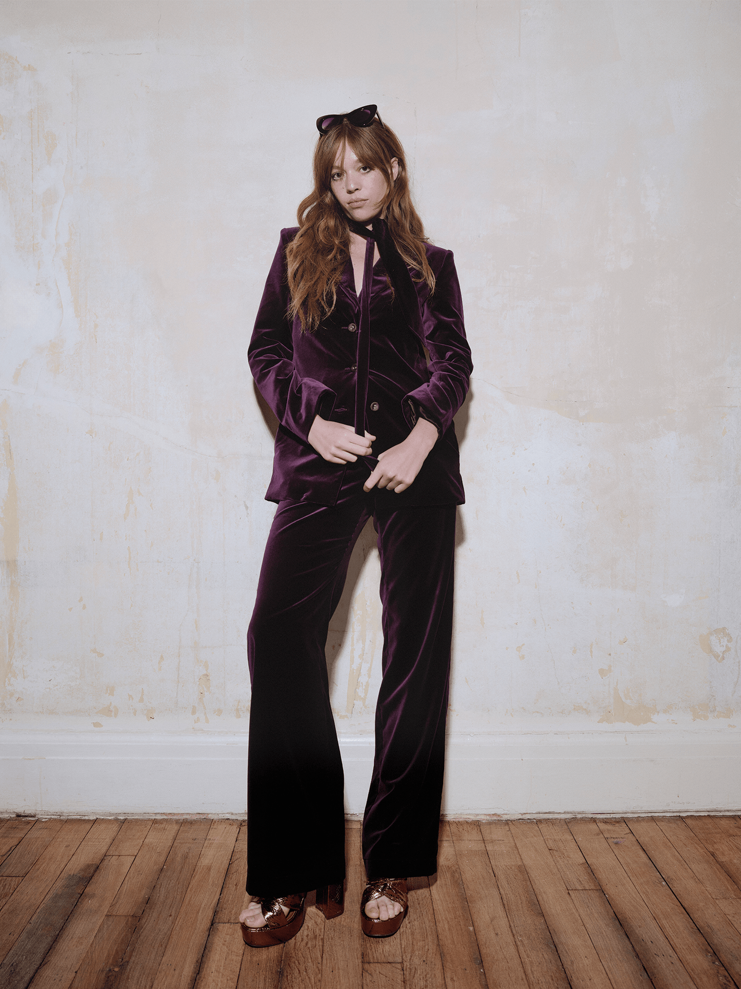 women modelling Cotton Velvet All-Day Suit Trousers in purple whilst leaning on  white wall