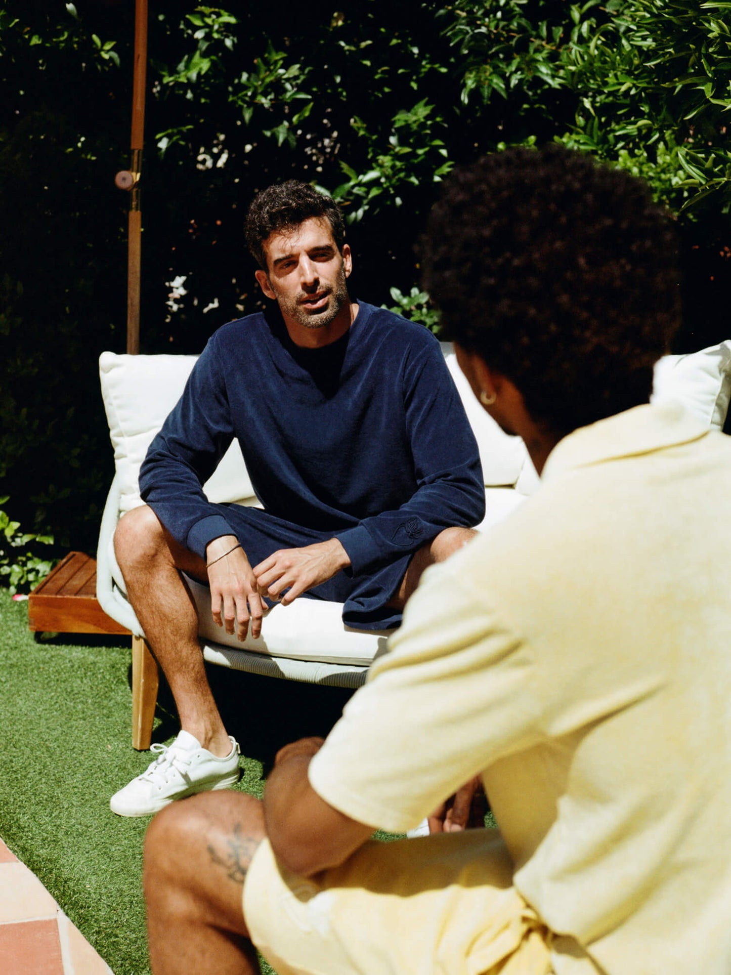 man wearing Organic Terry Long-sleeve in deep ocean blue sat on deckchair