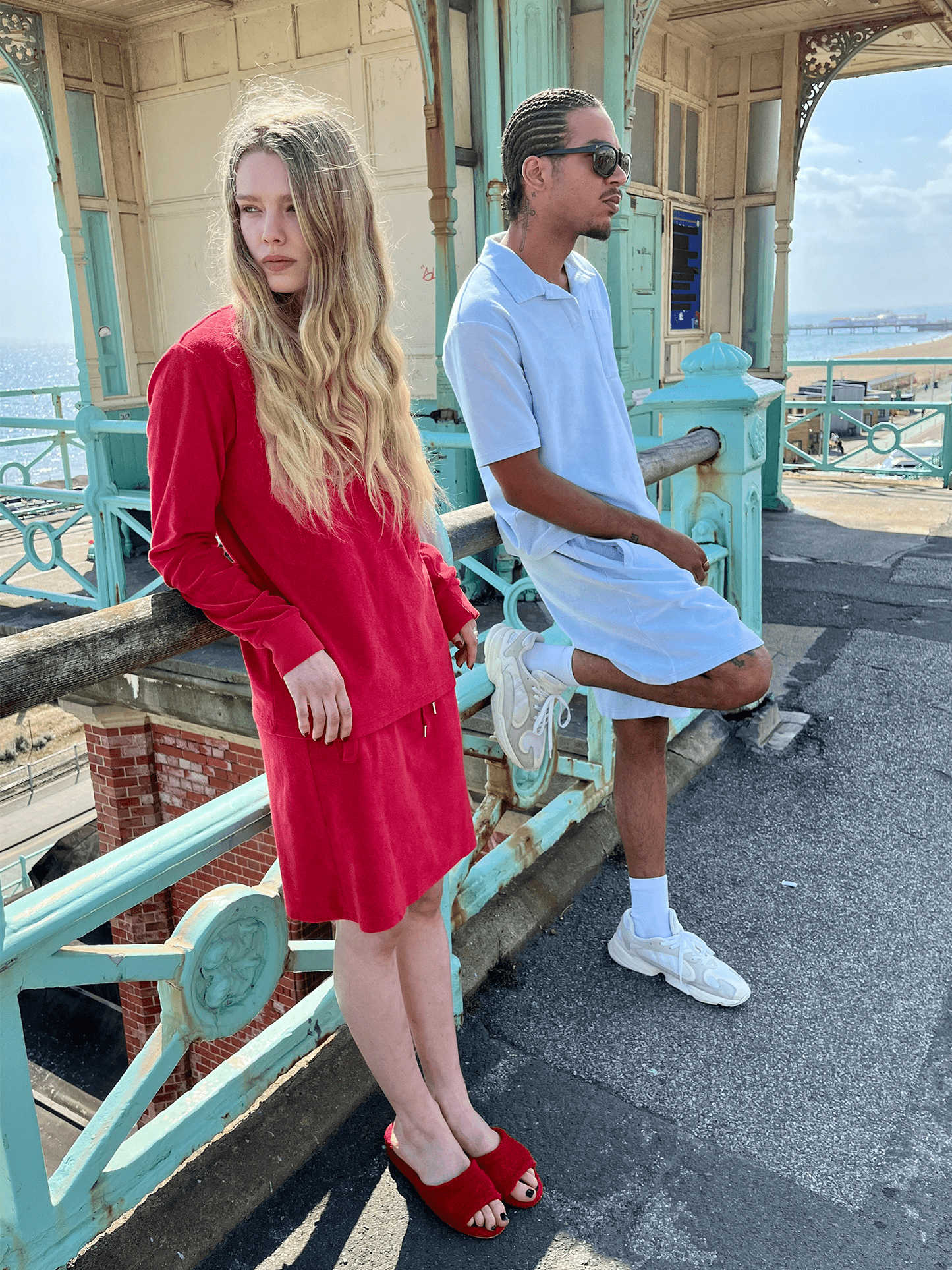 man wearing Organic Terry Polo in sky blue wiht woman in red outfit