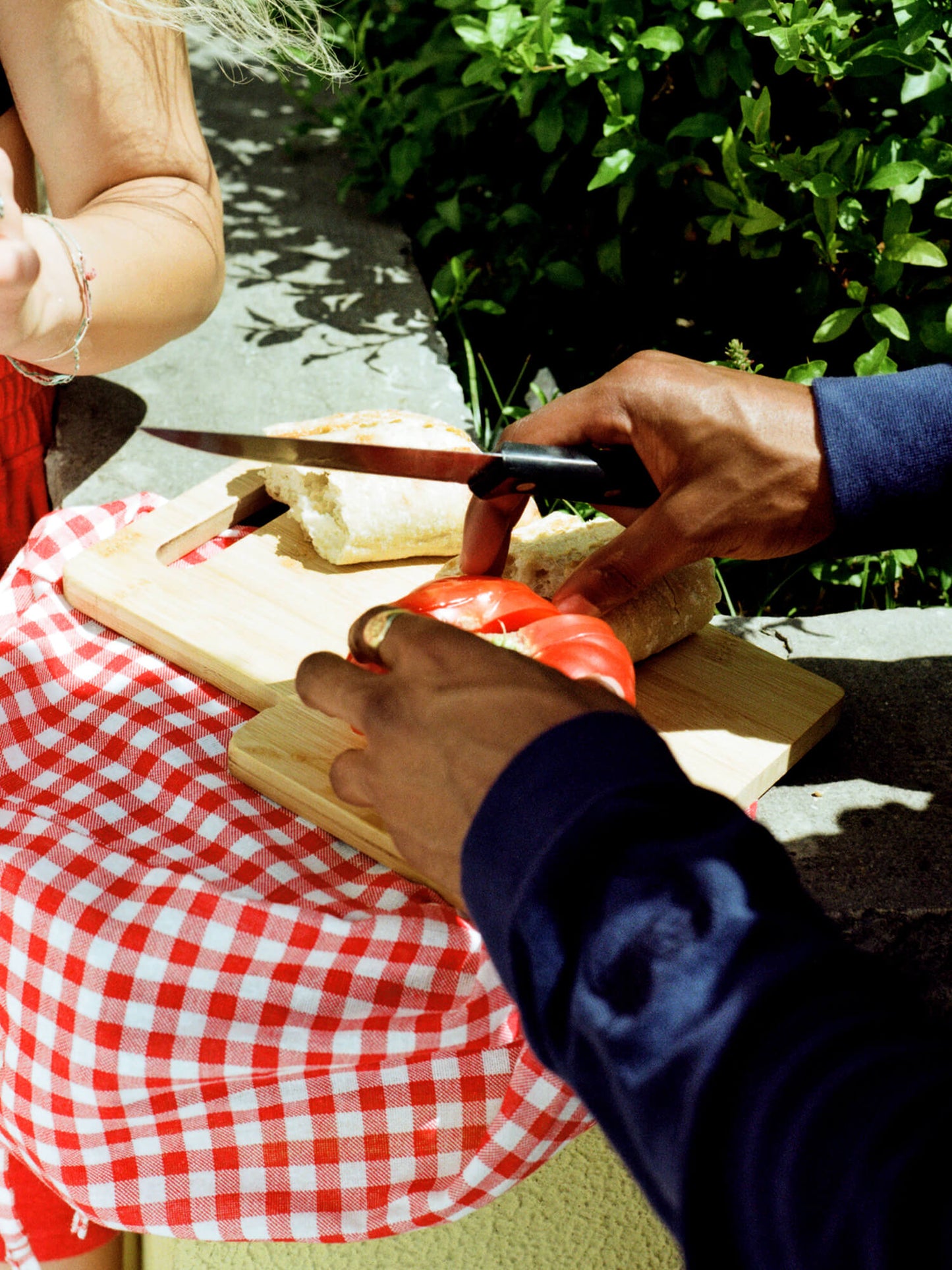 man cutting tomato wearing Organic Terry Long-sleeve in deep ocean blue