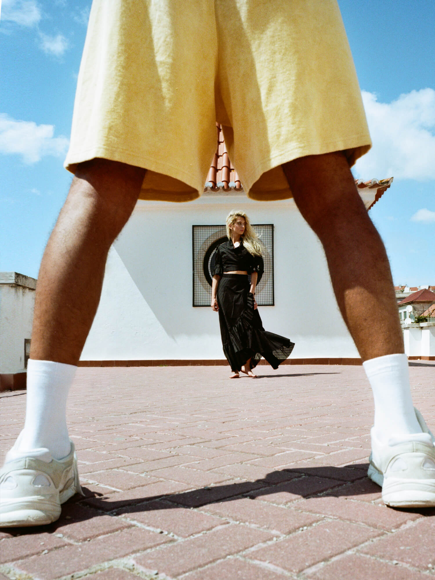 man wearing Organic Terry Shorts in golden sand wiht woman in background