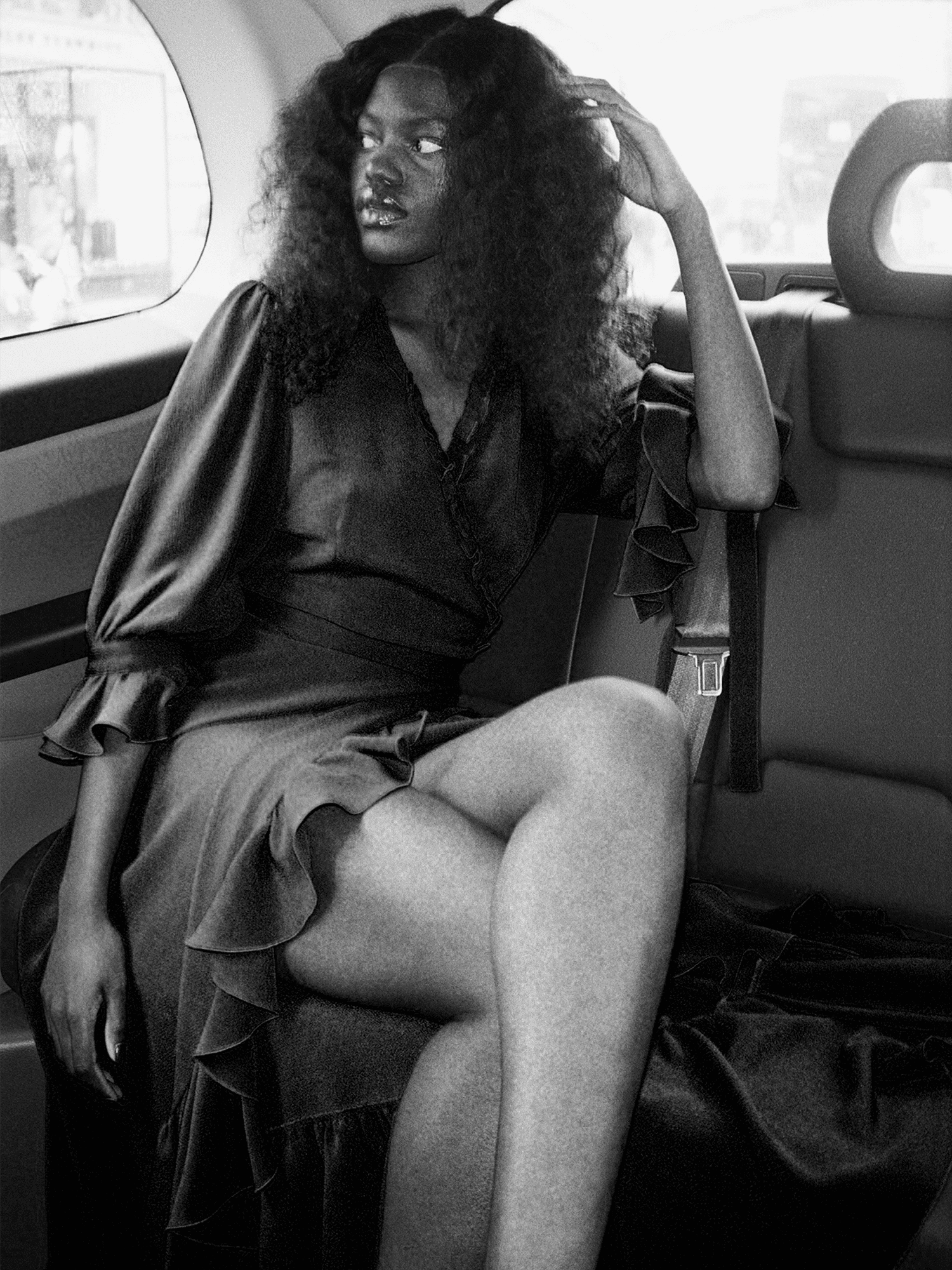 woman in back of car wearing The Wrap Dress in raven black